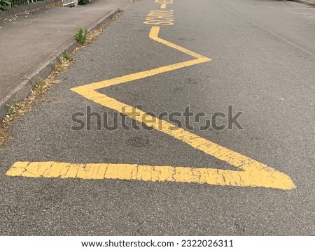 Yellow Zig Zag lines indicating to motorists to keep clear no parking taken outside school entrance UK Royalty-Free Stock Photo #2322026311