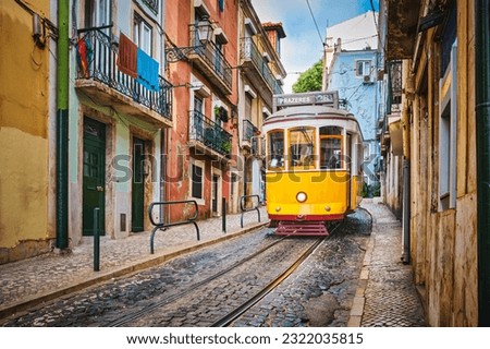 Famous vintage yellow tram 28 in the narrow streets of Alfama district in Lisbon, Portugal - symbol of Lisbon, famous popular travel destination and tourist attraction Royalty-Free Stock Photo #2322035815
