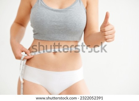 Lose weight, measuring tape or woman with thumbs up, success or fitness goals on white background. Measure, weightloss or girl in underwear with body target, stomach or like hand sign for wellness Royalty-Free Stock Photo #2322052391