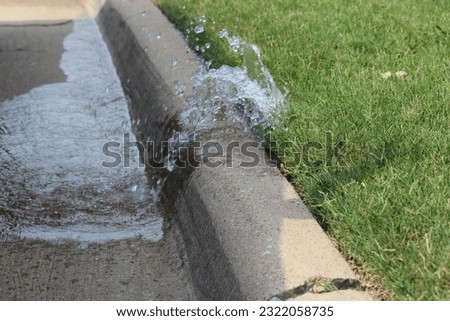 Water spilling from a broken sprinkler head Royalty-Free Stock Photo #2322058735