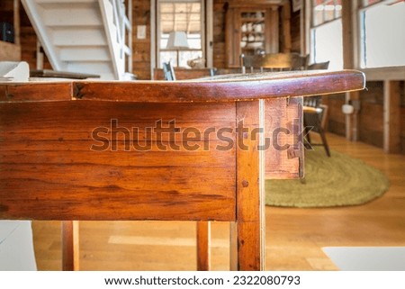 Antique wooden table with a warped top, and original joint has fractured. Possibly due to age or climate Royalty-Free Stock Photo #2322080793