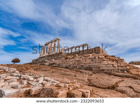 View from a distance of the Temple of Apollo, the ruined ancient Greek marble temple on the mountain top under blue sky