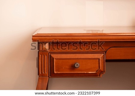 A classic style brown wooden table with a small drawer  Royalty-Free Stock Photo #2322107399