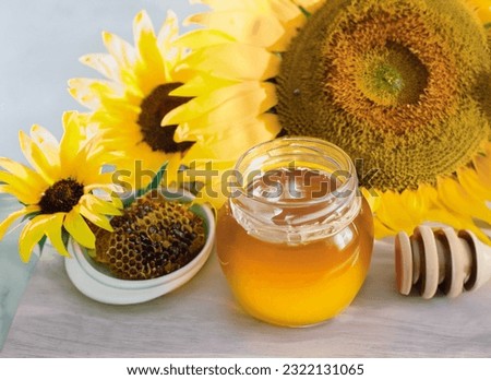 A Close-Up Shot of Sunflowers and A Honey jar