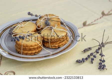 plate with lavender cookies. The cookies are decorated with lavender flowers. Homemade cakes, delicious perenya recipes. Dried lavender flowers. Horizontal.