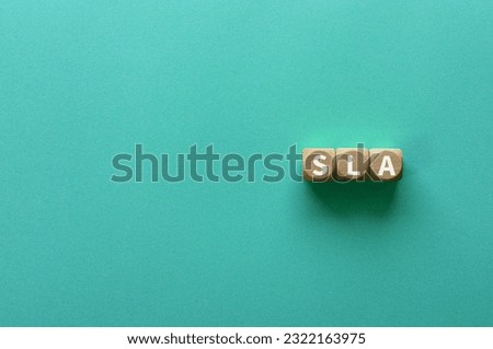 There is wood cube with the word SLA. It is an abbreviation for Service Level Agreement as eye-catching image.