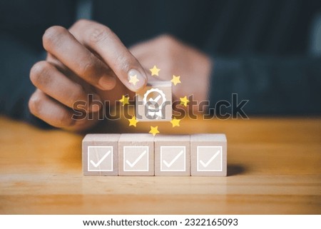 ISO quality control certification concept displayed through wooden cube with a check mark guarantee icon and smart globe ISO icons. Hand flipping the ISO icons represents certified management systems