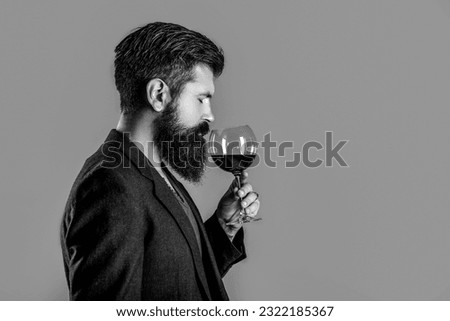Sommelier, degustator with glass of wine, winery, male winemaker. Man with a glass of red wine in his hands. Man sommelier tasting red wine. Black and white. Royalty-Free Stock Photo #2322185367