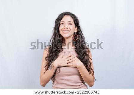 Positive woman with lovely sincere smile feeling thankful, relaxed person showing thank you gesture with hands on chest, Grateful people concept Royalty-Free Stock Photo #2322185745