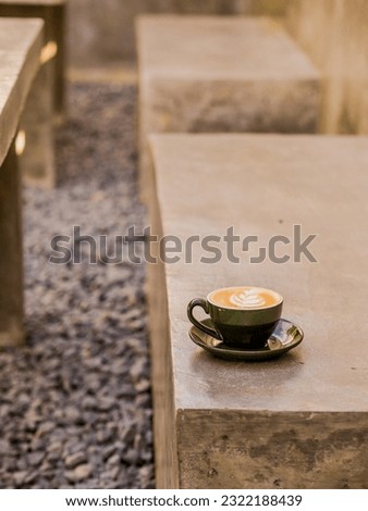 Coffee with green cup put under the shadow of tree combined with yellow color from sun is a great ambience Royalty-Free Stock Photo #2322188439