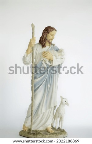 jesus holding a sheep and another sheep standing near to him