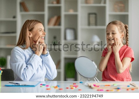 Logopedic Correction. Speech Therapist Woman Making Articulation Exercises With Little Girl During Therapy Meeting In Office, Child Development Specialist Having Session With Female Kid Royalty-Free Stock Photo #2322194749