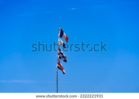 Flag of France blowing in the wind at Giens peninsula on a sunny spring day. Photo taken June 8th, 2023, Giens, Hyères, France.