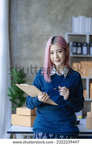 Asian woman preparing a delivery box for online shopping Beginners start small business owners at home, SME business concepts like shopping, online, vertical image.