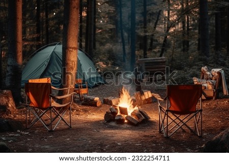 Beautiful bonfire with burning firewood near chairs and camping tent in forest Royalty-Free Stock Photo #2322254711