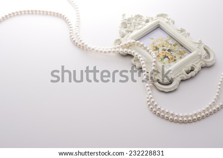 picture frame and pearl necklace on white The picture in the frame is my work.