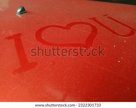 Heart shape drawn on the front of the parked car.