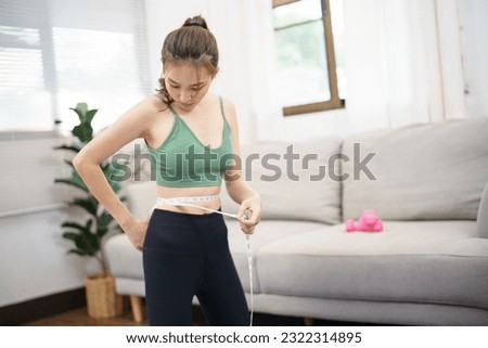 Asian woman with anorexia  with measuring tape feeling unhappy. Anorexia problem body perception and dysmorphia conceptใ Royalty-Free Stock Photo #2322314895