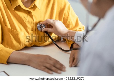 Doctor using a stethoscope checking patient stethoscope putting beat heart diagnose medical checkup cardiologist in examination room Royalty-Free Stock Photo #2322319371