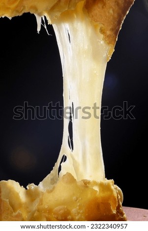 Melted cheese from a pastry (Pastel de feira tipico Brasileiro). Melted Mozzarella Cheese, Delicious Stretched Melted Hot Cheese, brazilian typical cuisine Royalty-Free Stock Photo #2322340957