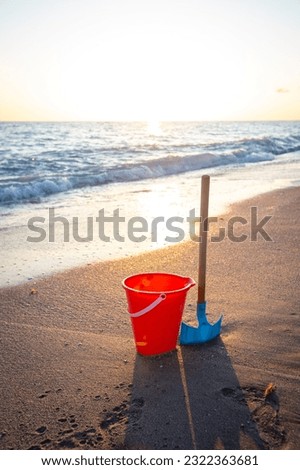 Bucket and shovel on the beach at sunset