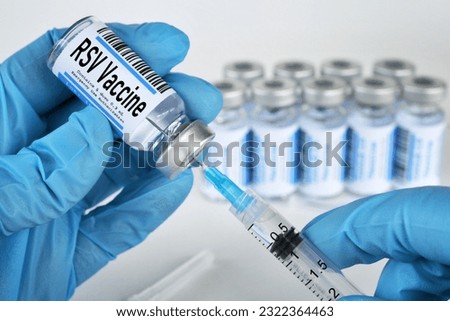 Medical personnel filling a syringe needle with RSV vaccine from vial Royalty-Free Stock Photo #2322364463