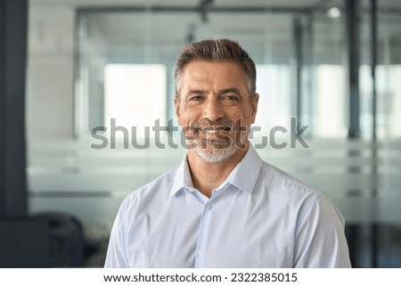Happy mid aged older business man executive standing in office. Smiling 50 year old mature confident professional manager, confident businessman investor looking at camera, headshot close up portrait. Royalty-Free Stock Photo #2322385015