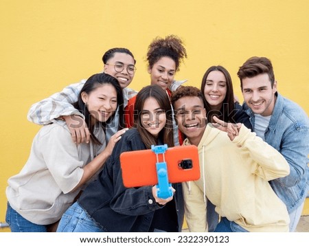 Group of diverse millennials recording a video or taking a photo for social media. Young people having fun with new technology 