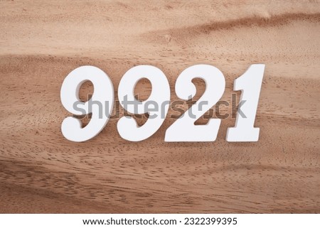 White number 9921 on a brown and light brown wooden background.