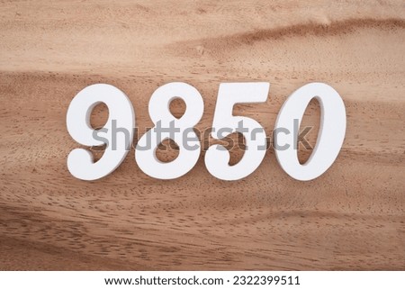 White number 9850 on a brown and light brown wooden background.