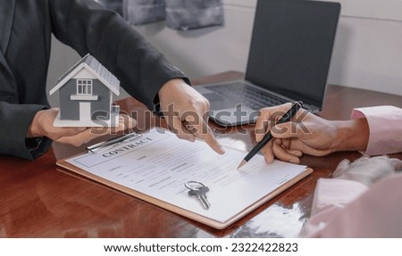 Hand signing on contract after the real estate agent explains the business contract, rent, purchase, mortgage, a loan, or home insurance to the buyer.