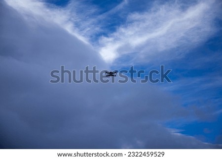 Drone flying in the blue sky with white clouds in the background