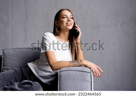 Portrait of smiling young woman talking cell phone in loft apartment