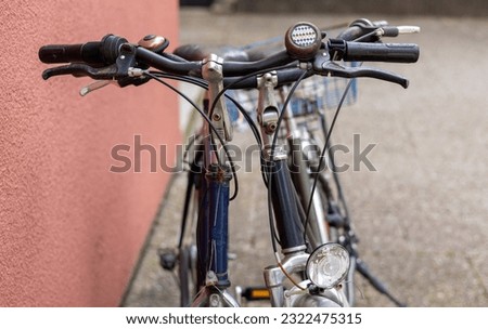 many bicycle on parking lot next to building urban city style street photo.close up wheel tires bike parts,basket,handlebars.bicycle in a row green nature apartments building