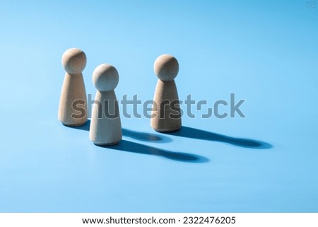 A wooden business teamwork symbol. Leadership styles concept of strategy cooperation. A group of employee from the company. The wooden symbol with light blue background. Professional business group.