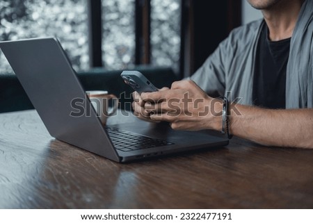 Young beard man using laptop on office, freelance work, outdoor close up hipster portrait, brutal, guy listening music on earphones, make photo and video, production, Bali. coffee, smartphone