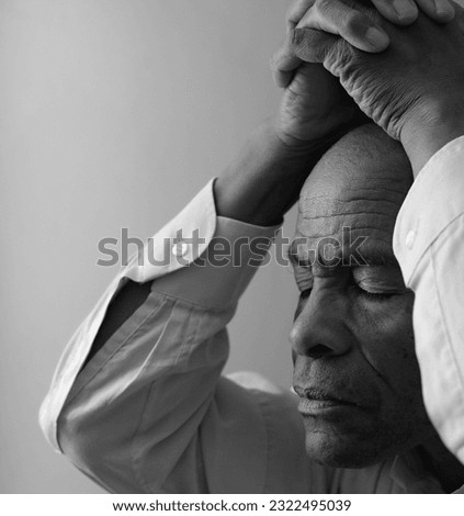 black man praying to god with hands together Caribbean man praying stock photo	