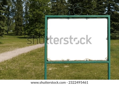 Empty white sign with antique metallic frame in a public park