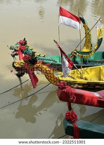 Head of dragon boat and Indonesian flag in the river