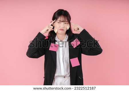 pretty woman with sticky notes finger on head skull brainstorming and thinking about pensive challenge problem isolated on pink background