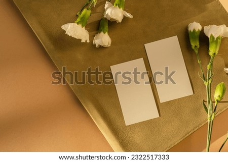 Blank paper sheet card with mockup copy space and carnation flowers. Aesthetic sunlight shadows. Minimal business brand template