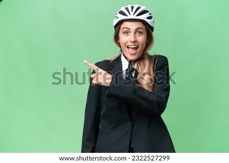 Business Uruguayan woman wearing a helmet biker over isolated background surprised and pointing side