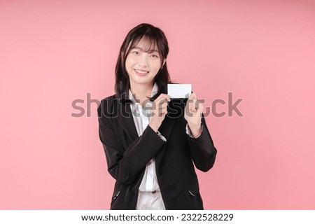 Business woman holding blank card. Isolated pink background