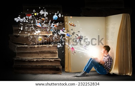 Teenager boy in jeans and shirt reading book
