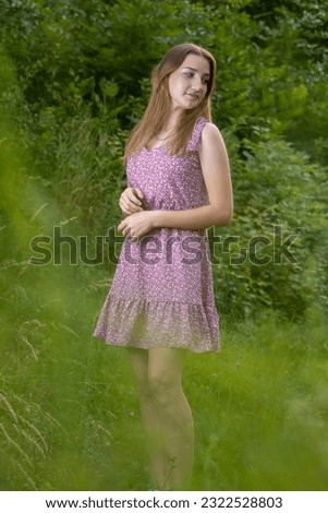 A young girl in a dress on a green background.