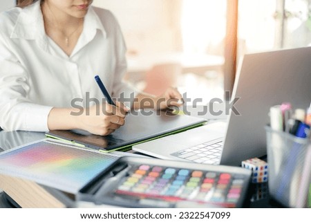 Graphic designer using graphics tablet to do his work at desk