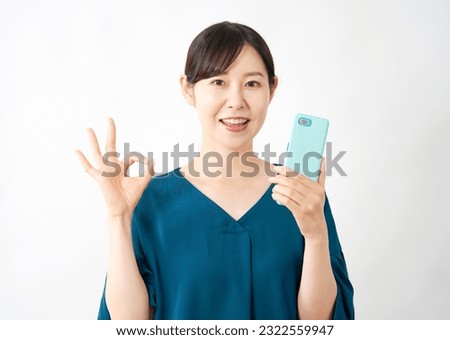 Asian middle aged woman with the smartphone OK gesture in white background round