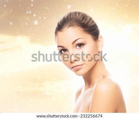 Face of young and healthy girl over winter background with a snowflakes 