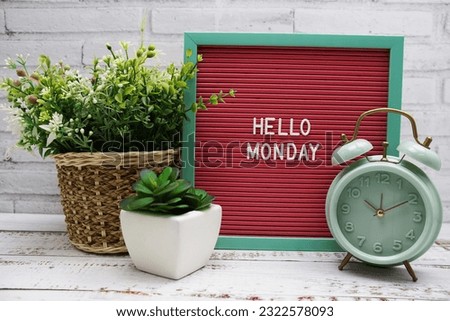 Hello Monday text on Letter Board with alarm clcok and artificial plant decoration