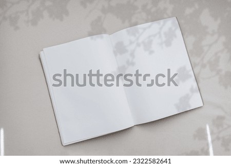 Flower Silhouette Shadow on Empty Book,Top view Open Note Book with Leaves shadow overlay on Canvas Texture Background,Flat lay Blank Diary mockup with white paper